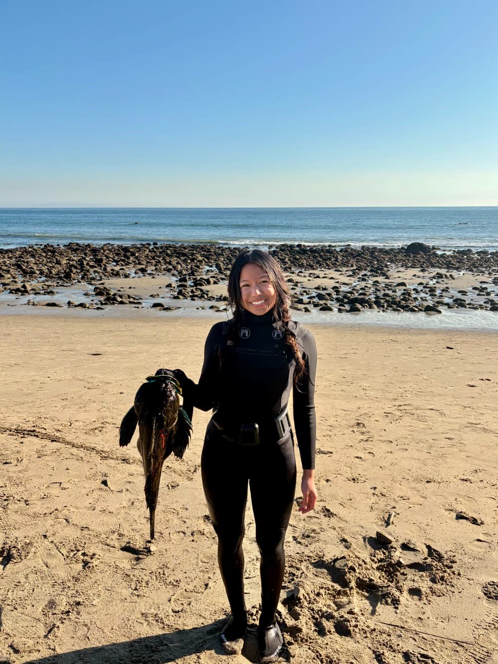 Mal Corpuz on the beach in a wetsuit after a spearfishing dive