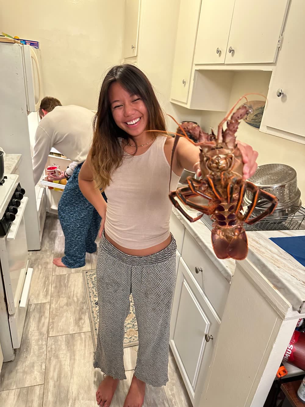 Mal Corpuz holding a California spiny lobster in the kitchen